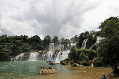 Scenic view of waterfall against sky