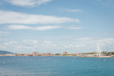 City buildings by sea against sky