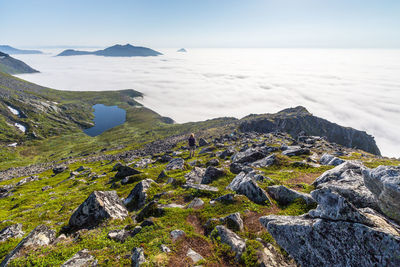 Rear view of woman on mountain against cloudscape