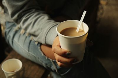 Midsection of woman holding coffee cup