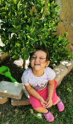 High angle portrait of cute girl sitting against plants