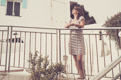 Woman standing at railing in city