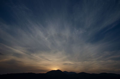 Low angle view of silhouette mountain against dramatic sky