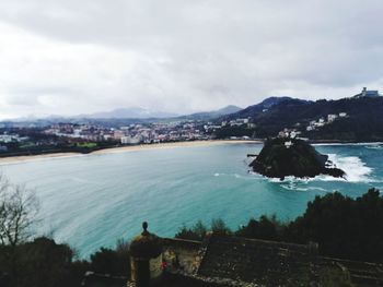 Rear view of man standing by sea against sky