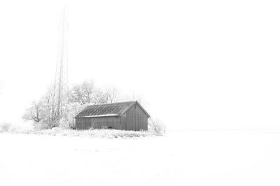 Built structure on snow covered landscape against clear sky