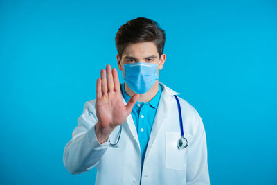 Portrait of young man against blue background