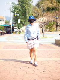 Rear view of man walking on footpath