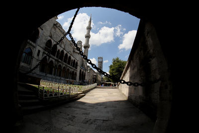 Road through a gate to the bluetooth mosque against sky in citybof istanbul