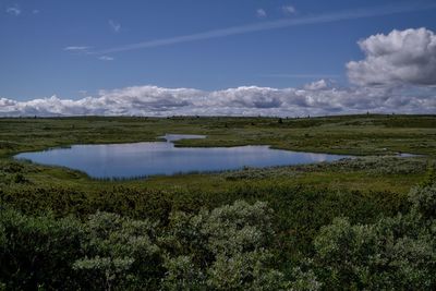 Scenic view of lake against cloudy sky