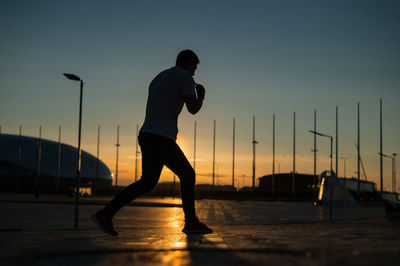 Rear view of silhouette man walking on street