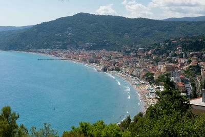 High angle view of city by sea against sky