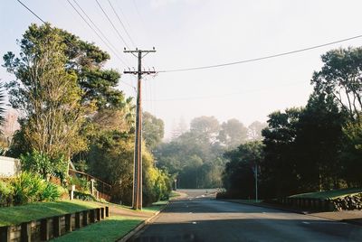 Road by trees against sky