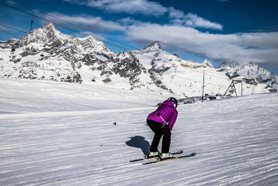 People skiing on snowcapped mountain against sky