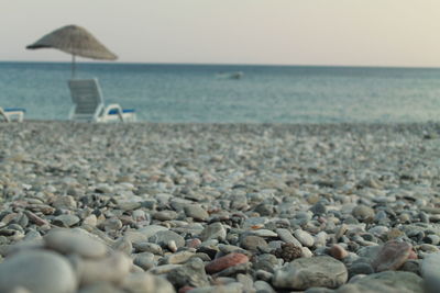 Surface level of pebbles on beach against sky