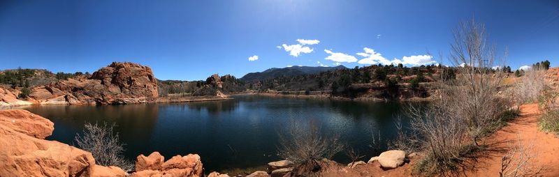 Panoramic view of lake and mountains against blue sky