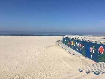 Scenic view of beach against clear blue sky