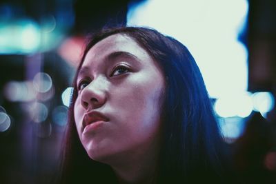 Close-up portrait of a young woman looking away