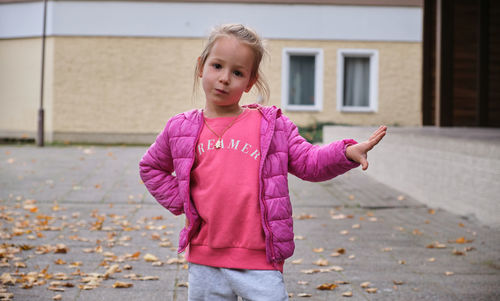 Portrait of girl standing against wall