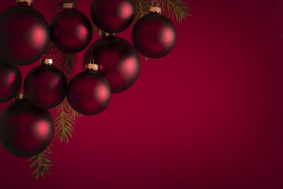 Close-up of red christmas ornaments hanging against wall