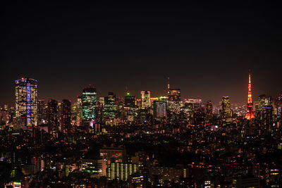 Illuminated buildings in city against sky at night