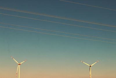 Low angle view of wind turbine against clear blue sky