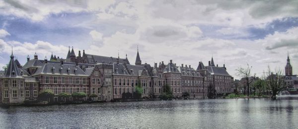 Buildings in city against cloudy sky