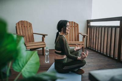 Side view of woman sitting on table