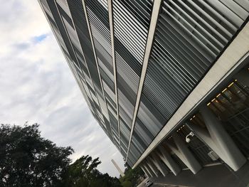 Low angle view of modern building against cloudy sky