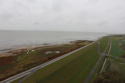 Scenic view of road by sea against sky