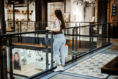 Black friday sale. young latina woman with shopping bags standing in modern shopping center, mall.