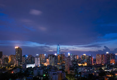 Illuminated buildings in city against sky at night