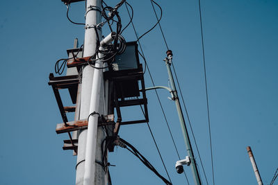 Low angle view of electricity pylon against clear sky