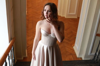 High angle view of beautiful woman wearing dress while standing on staircase