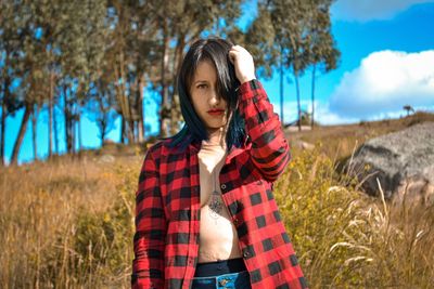 Portrait of young woman standing on field