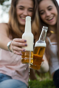 Happy friends toasting beer bottles