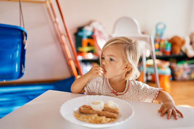 Portrait of boy eating food at home