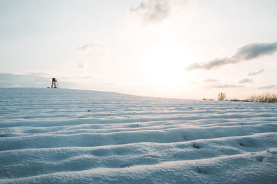 Man on snow covered land against sky