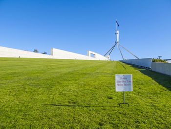 Information sign on field against clear sky