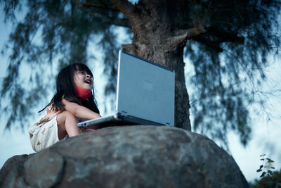 Woman looking at tree trunk