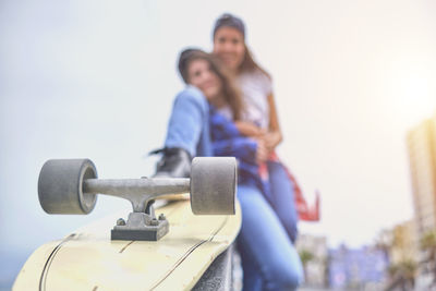 Attractive female friends having fun riding skateboards at the skate park. selective focus