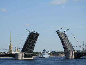 Bridge by river against sky in city