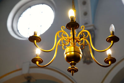 Low angle view of lit chandelier in church