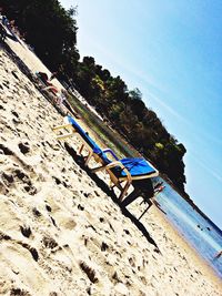 Low angle view of deck chairs against blue sky