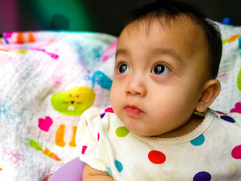 Close-up portrait of cute baby girl in bed