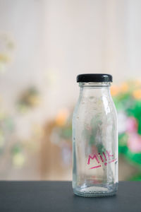 Empty milk bottle with text on table