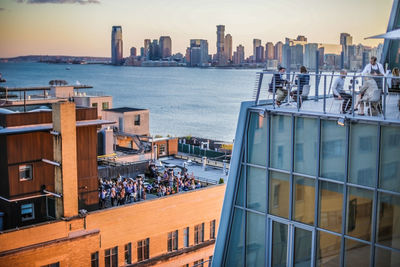 View of city at waterfront during sunset