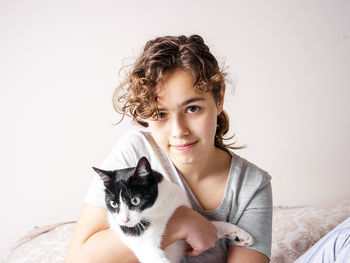 Portrait of woman with cat against white background