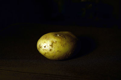 Close-up of lemon on table against black background