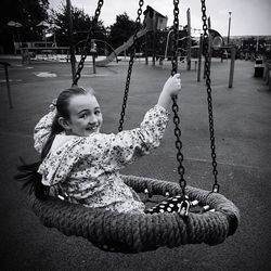 Girl sitting on swing at park