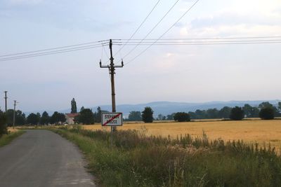 Road amidst field against sky
